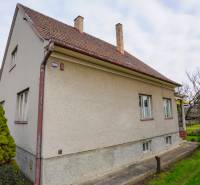 Rodinný dům na Nerudově ulici v Dubnici nad Váhom, obklopený zelení a stromy.