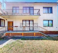 Rodinný dům v Malackách s balkónem a garáží, obklopený zahradou.