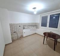 Pokoj v rodinném domě s bílými stěnami, oknem a dlaždicemi.