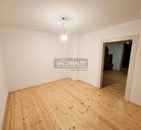 Prázdná místnost v rodinném domě s podlahou s dřevěným dekorem a jednoduchým osvětlením.