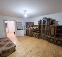 Pokoj v rodinném domě s nábytkem a podlahou s dřevěným dekorem.