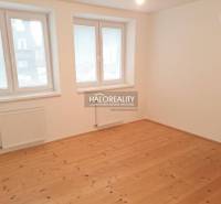 Pokoj v rodinném domě s podlahou s dřevěným dekorem a bílými stěnami.