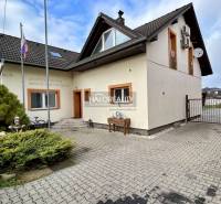 Rodinný dům v Prievidzi s asfaltovým dvorem, zahradou a satelitní anténou.