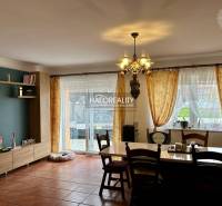 Jemně osvětlená jídelna v rodinném domě s dřevěným dekorem podlahy.