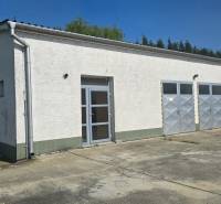 Bílá budova s kovovými dveřmi ve skladové a halové zóně města Šaľa.