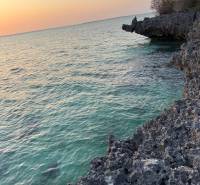 Pobřežní útesy a západ slunce nad jemnými vlnami moře v Kizimkazi, Pozemky - komerční.