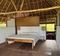 Dřevěná postel v chatě s podlahou s dřevěným dekorem pro komerční pozemky.