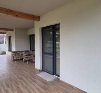 Terasa rodinného domu ve Studienke s houpací houpačkou a nábytkem, podlaha s dřevěným dekorem.