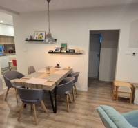 Jídelna v rodinném domě s dekorem dřevěné podlahy a stolem pro šest osob.