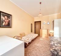 Izba s obrazom, posteľou, dreveným nábytkom a kobercom v 2-izbovom byte.