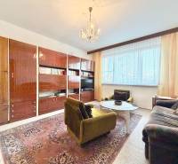 Obývacia izba v 2-izbovom byte s retro nábytkom a kobercom.