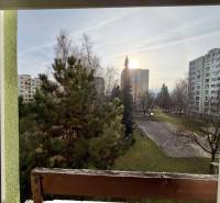 Pohľad z 2-izbového bytu na ulici Smreková v Žiline so zeleňou a panelákmi.