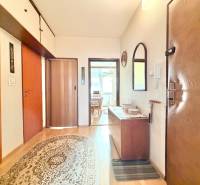 Chodba v 2-izbovom byte so skrinkami, kobercom a podlahou s dreveným dekorom.