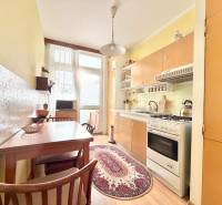 Kuchyňa v 2-izbovom byte s nábytkom a podlahou s dreveným dekorom.