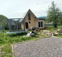 Chata v Hliníku nad Hronom s trampolínou a kamenitou cestou v zahradě.