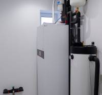 Zařízení koupelny v rodinném domě s bojlery a trubkami, světlé stěny.