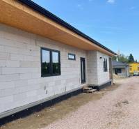 Rodinný dům v Radavě během výstavby s nezateplenou fasádou a štěrkovou cestou.