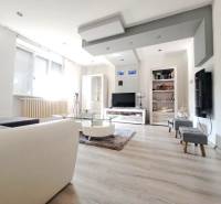 Obývací pokoj v rodinném domě s podlahou s dřevěným dekorem a pohovkou.