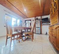 Jídelna v rodinném domě s dřevěným stropem a dlažbou.