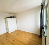 Pokoj v rodinném domě s bílou skříní a podlahou s dřevěným dekorem.