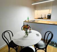 Jídelna v rodinném domě s kulatým stolem, květinami a podlahou s dřevěným dekorem.