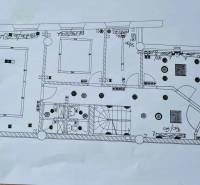 Půdorys obchodních prostor s koupelnami a schodištěm, včetně označení elektrických zařízení.