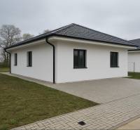 Rodinný dům v Cíferi se šikmou střechou a dlážděným chodníkem.