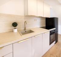 Kuchyně v 2pokojovém bytě s podlahou s dřevěným dekorem a moderním vybavením.