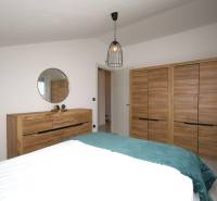 Pro Rekreační apartmán jsou typické skříně a komoda s dřevěným dekorem a zrcadlem.