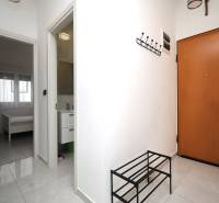 Rekreační apartmán s dlažbou, věšákem, otevřenými dveřmi do ložnice a koupelny.