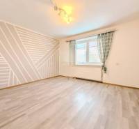 Pokoj v rodinném domě s geometrickou malbou a podlahou s dřevěným dekorem.