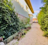 Zahrada u rodinného domu v Betliari s bohatým porostem a květinovými dekoracemi.