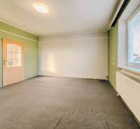 Interiér rodinného domu s barevnými stěnami, kobercem a oknem se žaluziemi.