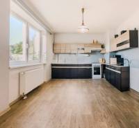 Kuchyně v rodinném domě s podlahou s dřevěným dekorem a velkým oknem.