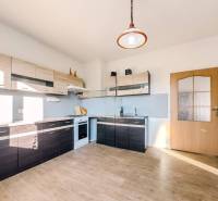 Kuchyně v rodinném domě s podlahou s dřevěným dekorem a moderními linkami.