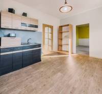 Kuchyně v rodinném domě s podlahou s dřevěným dekorem a světlým interiérem.