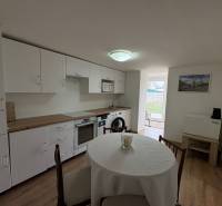 Kuchyně v 1-pokojovém bytě s podlahou s dřevěným dekorem a jídelním stolem.