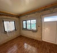 Interiér s podlahou s dřevěným dekorem a bílými dveřmi v části Zahrady.