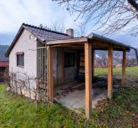 Chata v okrajové části Prešova obklopená podzimní přírodou a stromy.