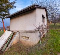 Chata v Prešově obklopená zelení, s jednoduchou omítkou a venkovním vchodem.