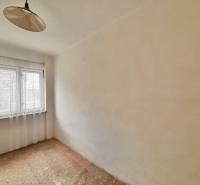 Pokoj v rodinném domě s jedním oknem a závěsem, s kobercovou podlahou.