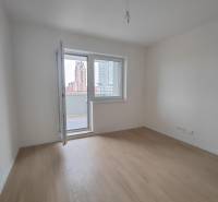 Pokoj v 2-pokojovém bytě s podlahou s dřevěným dekorem a balkonem.