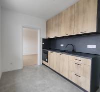 Kuchyně v 2-pokojovém bytě s podlahou s dřevěným dekorem a keramickou dlažbou.