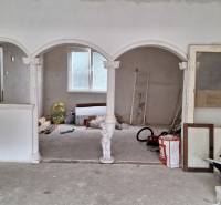 Interiér rodinného domu s oblouky a sloupy, neúplná renovace.