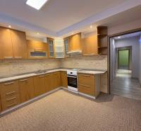 Kuchyně ve 3-pokojovém bytě s dřevěným dekorem a vestavěnými spotřebiči.