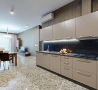 Kuchyně v 3-pokojovém bytě s mramorovou podlahou a světlým nábytkem.