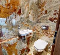 Koupelna s výrazným kamenným obkladem v 3-pokojovém bytě.