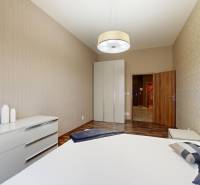 Ložnice v 3pokojovém bytě s podlahou s dřevěným dekorem a vestavěnou skříní.