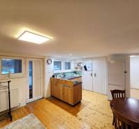 Kuchyňa v 1-pokojovém bytě s podlahou s dřevěným dekorem a stolem.