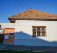 Rodinný dům v Nových Zámcích na ulici Pod kopcem s cihlovou střechou a plechovou bránou.